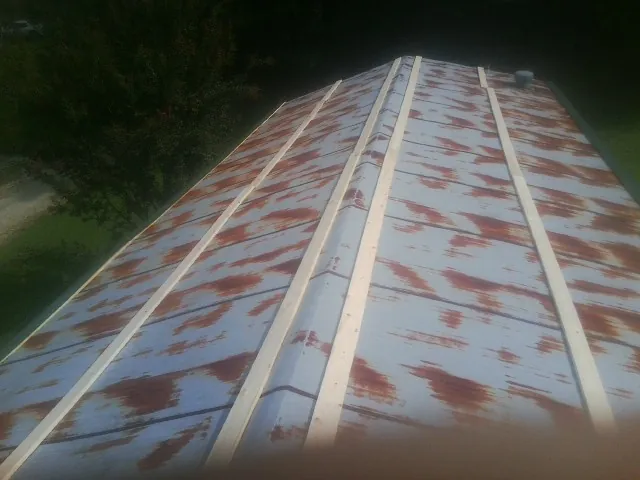 Rusted metal roof panels with new wood purlins before replacement — Storm Damage Roof Repair in Safety Harbor by Roofing Brothers