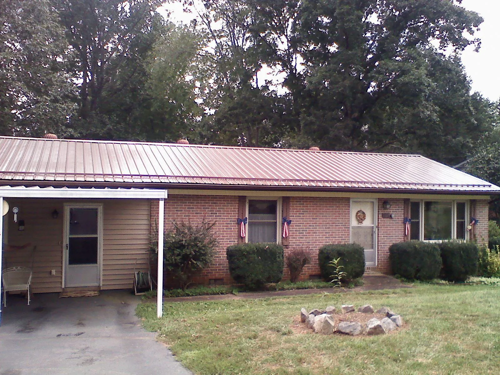 Bronze metal roof and carport on a brick ranch home — Roof Repair work by our crew in Safety Harbor
